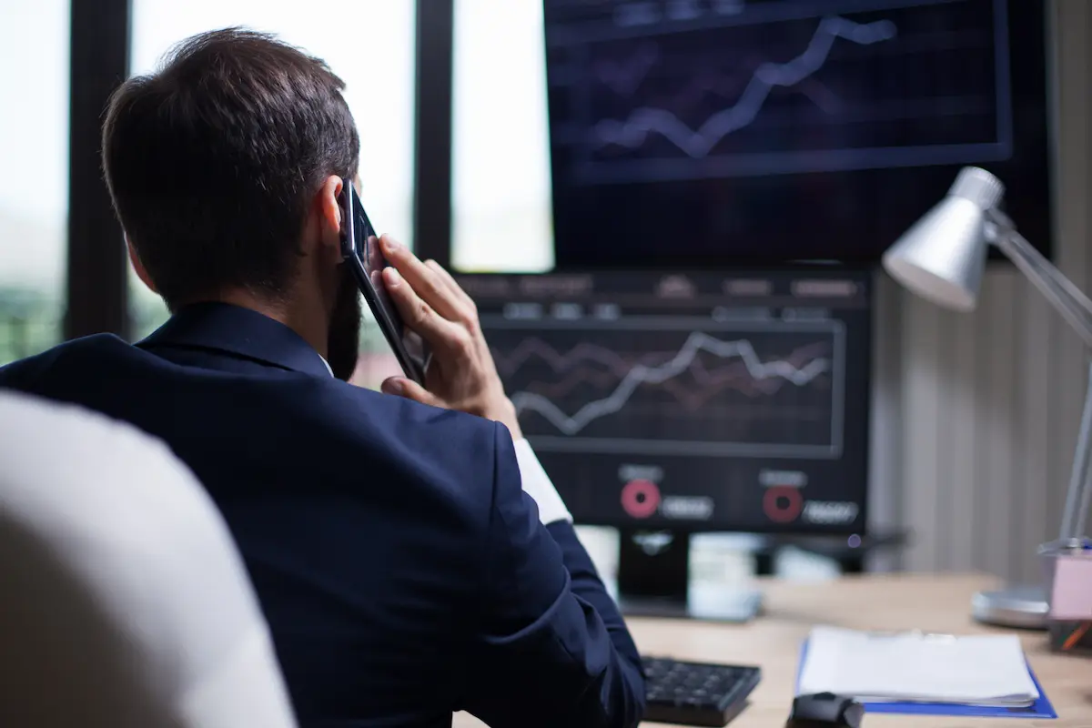 Homem ao telefone em ambiente de trabalho, simbolizando cuidado com falsa central, ligações suspeitas e como proteger dinheiro de golpes financeiros.