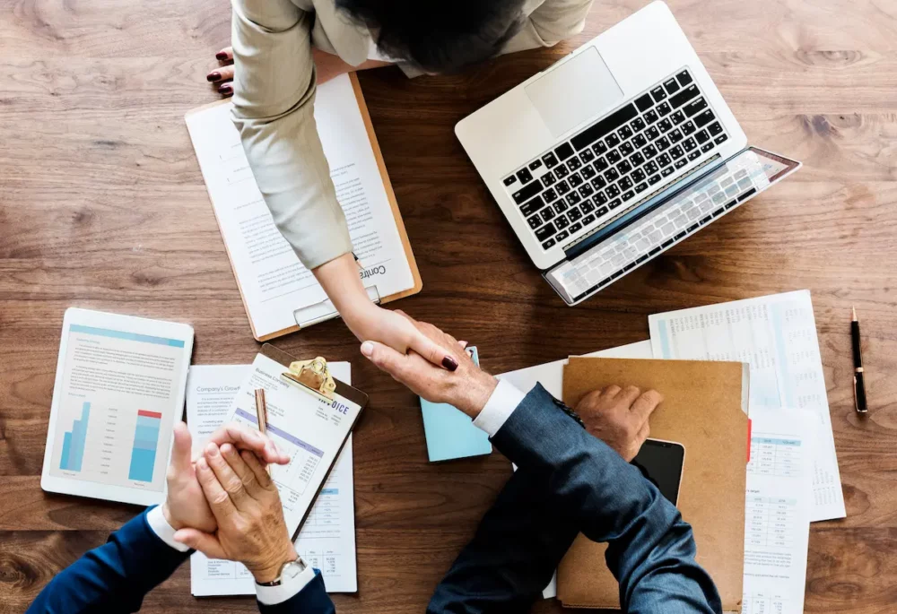 Pessoas finalizando a contratação de um financiamento sem entrada com um aperto de mão