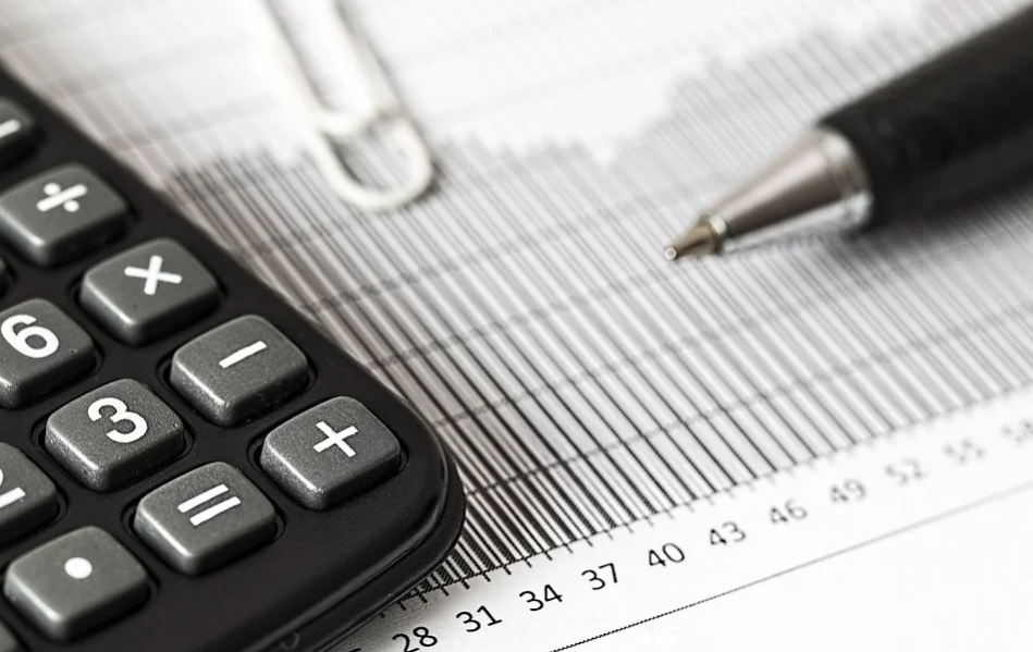 calculadora e caneta pretas sob gráficos de rendimento entre corretora ou banco