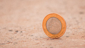 moeda de um real em pé em uma superfície irregular