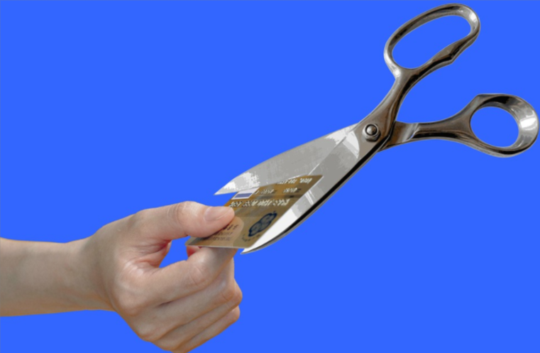 Tesoura cortando um cartão de crédito ao meio