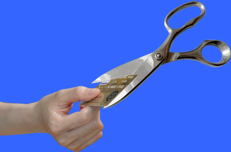 cartão de crédito sendo cortado por tesoura no ar