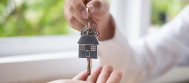 imagem ampliada de uma pessoa recebendo as chaves de sua nova casa