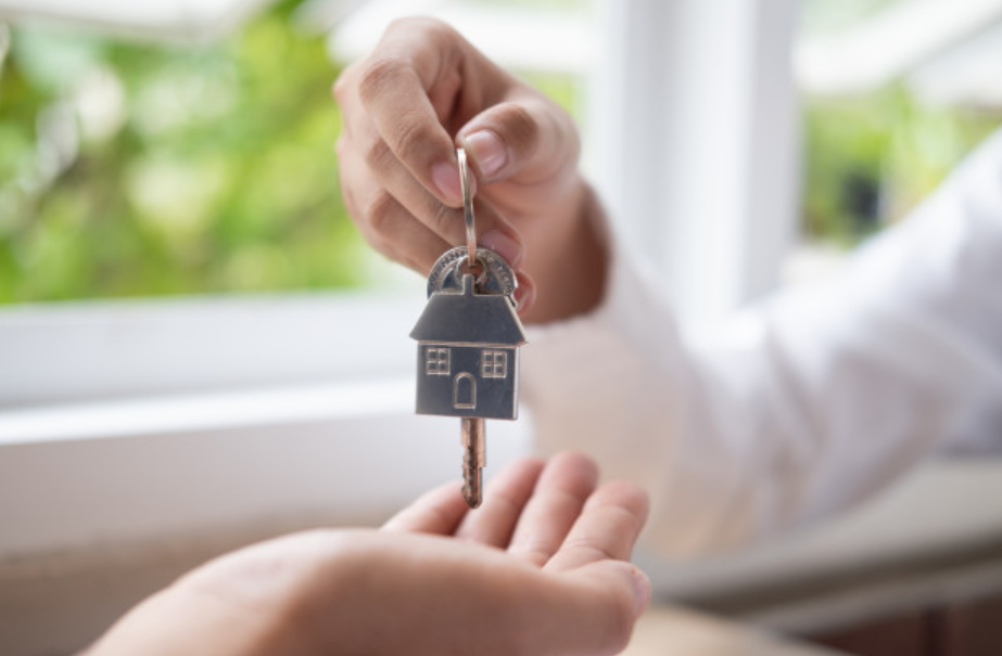 imagem ampliada de uma pessoa recebendo as chaves de sua nova casa
