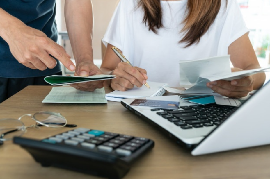 homem de mulher sentados a mesa fazendo cálculos para contratar empréstimos