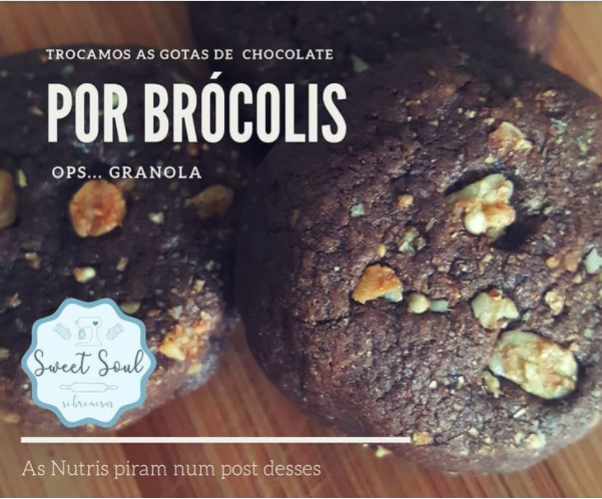 em uma mesa de madeira estão dois cookies de chocolate com as escritas: trocamos as gotas de chocolate por brócolis ops... granola