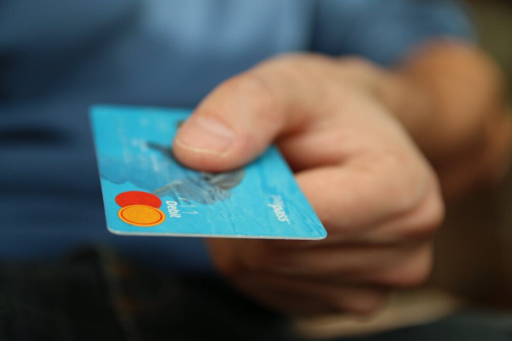 imagem ampliada de um homem segurando um cartão de crédito azul
