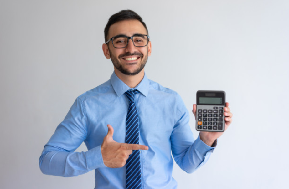jovem de camisa azul e gravata segurando uma calculadora com a mão esquerda 