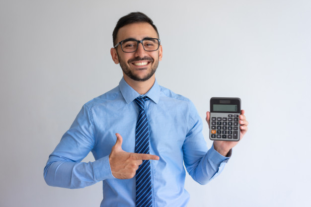 homem de camisa azul e óculos de grau sorri enquanto aponta para uma calculadora