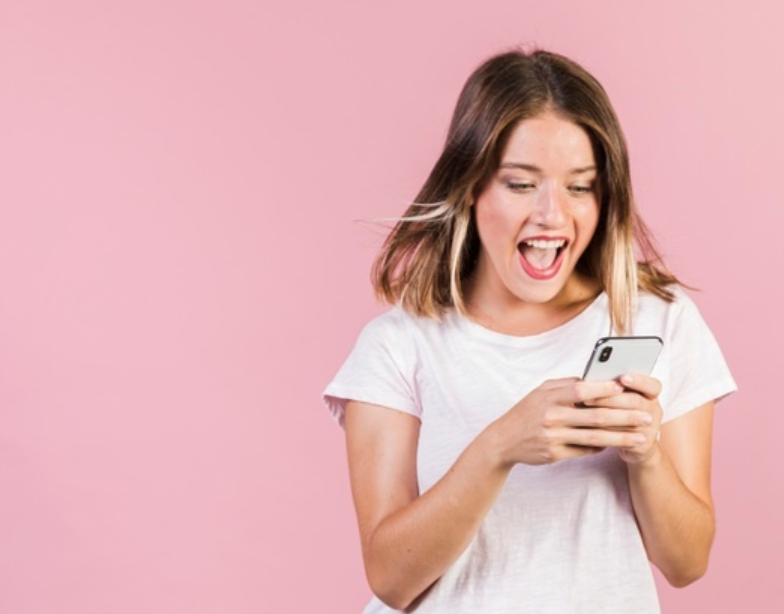 mulher de roupa branca em frente a um fundo rosa usando o celular para responder pesquisa