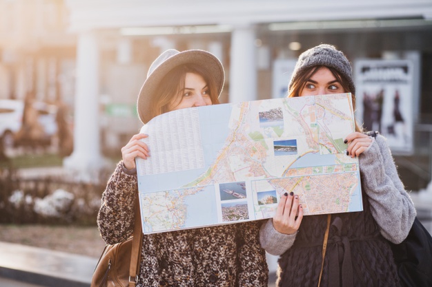 duas amigas segurando um mapa de papel