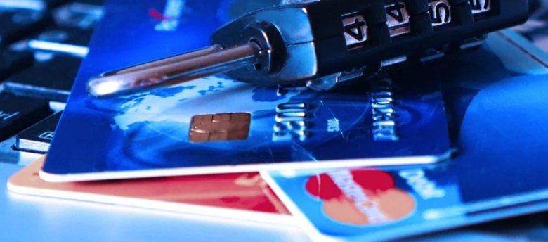 cartões de crédito em cima de um teclado com um cadeado por cima