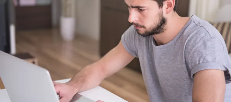 homem em casa mexendo no notebook - cpf negativado