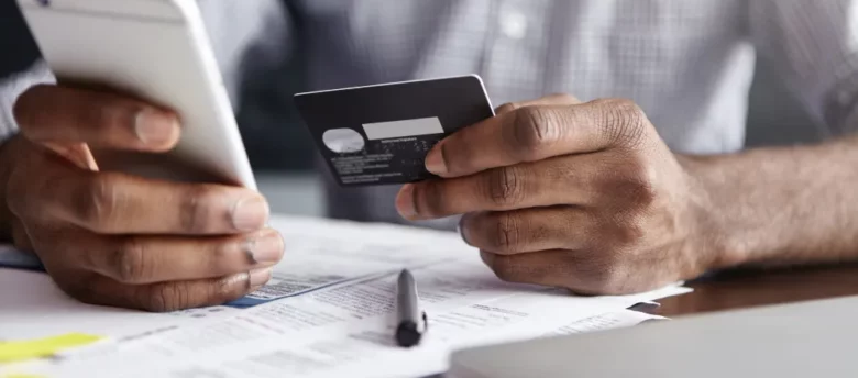 homem-segurando-cartao-e-celular-empréstimo cartão de crédito