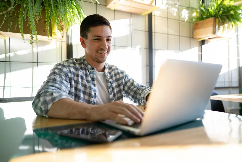 homem trabalhando atrás do computador - empréstimo com garantia de salário