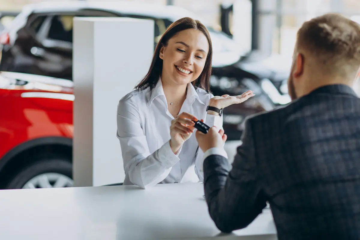 Mulher ao comprar carro sem entrada recebendo a chave do veículo