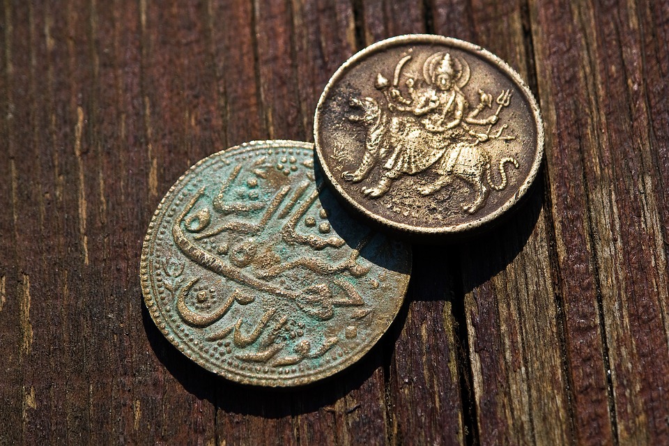 Duas moedas antigas e enferrujadas em uma mesa de madeira