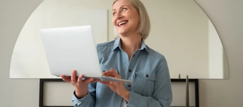 mulher de idade em pé segurando notebook - cálculo revisão da vida toda