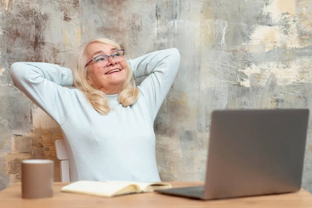 mulher de itade relaxada na frente do computador - empréstimo pessoal para aposentado negativado