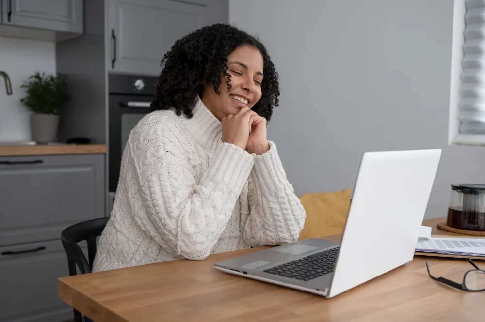 mulher negra feliz sorridente mexendo no computador - empréstimo de 1500 reais para negativado