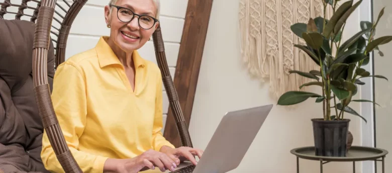mulher-senior-sorrindo-trabalhando-em-seu-laptop-empréstimo consignado para aposentado