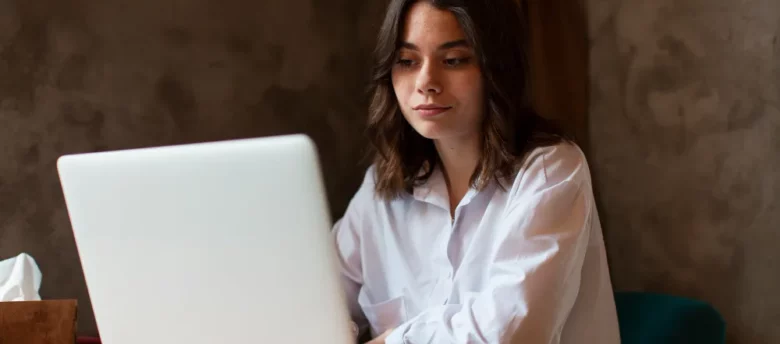 mulher sentada mexendo no computador em casa - negativação indevida