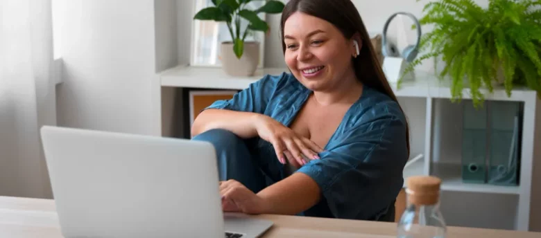 mulher sorridente mexendo no computador em casa - empréstimo com garantia do fgts