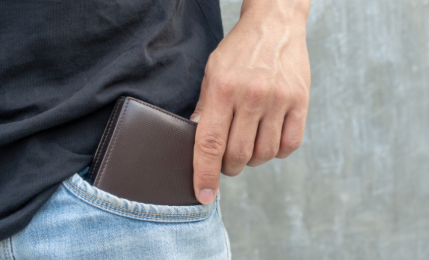 imagem de um homem tirando a carteira do bolso de sua calça jeans
