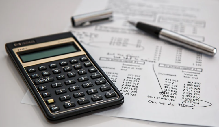 Calculadora financeira sobre um papel com extrato e caneta.