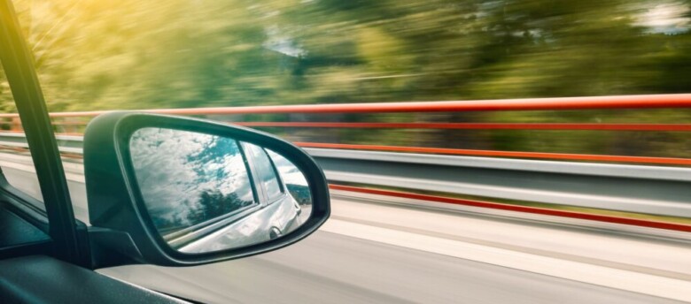 imagem de um espelho retrovisor em um carro em movimento