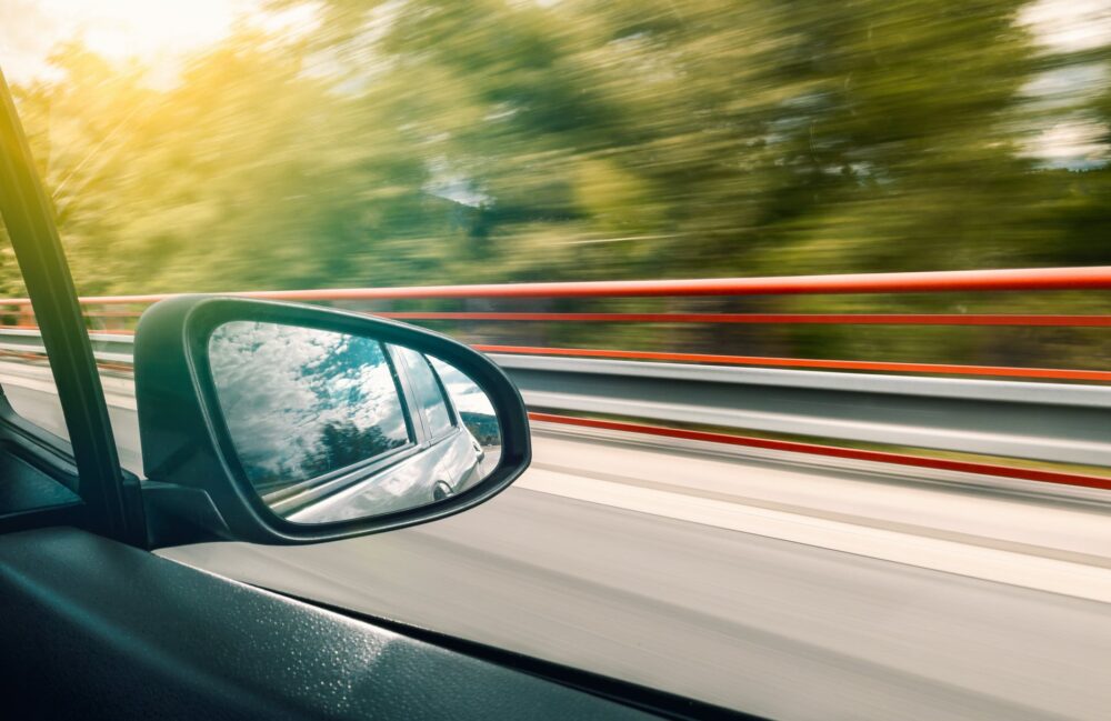imagem de um espelho retrovisor em um carro em movimento