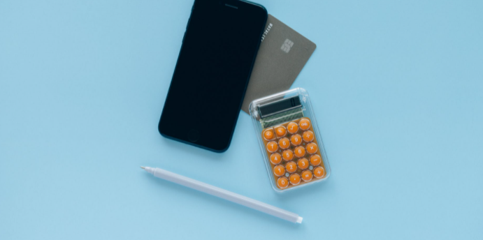 fundo azul com celular, calculadora, caneta e cartão