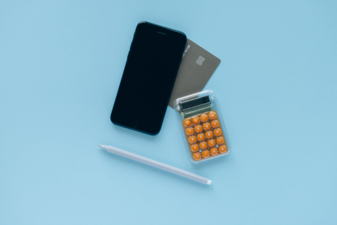 fundo azul com celular, calculadora, caneta e cartão
