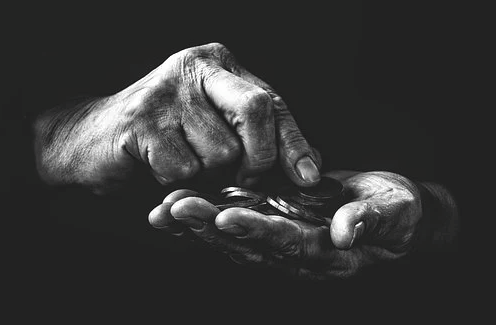 imagem em preto e branco de mãos segurando moedas 