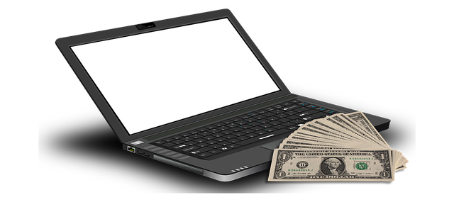 computador com a tela branca com notas de dólar próximo ao objeto
