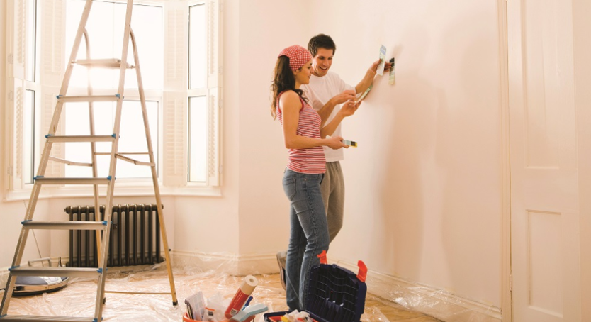 casal reformando a casa juntos e pintando as paredes