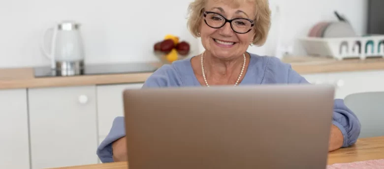 vista frontal de senhora usando computador em casa - cartão de crédito para aposentado negativado