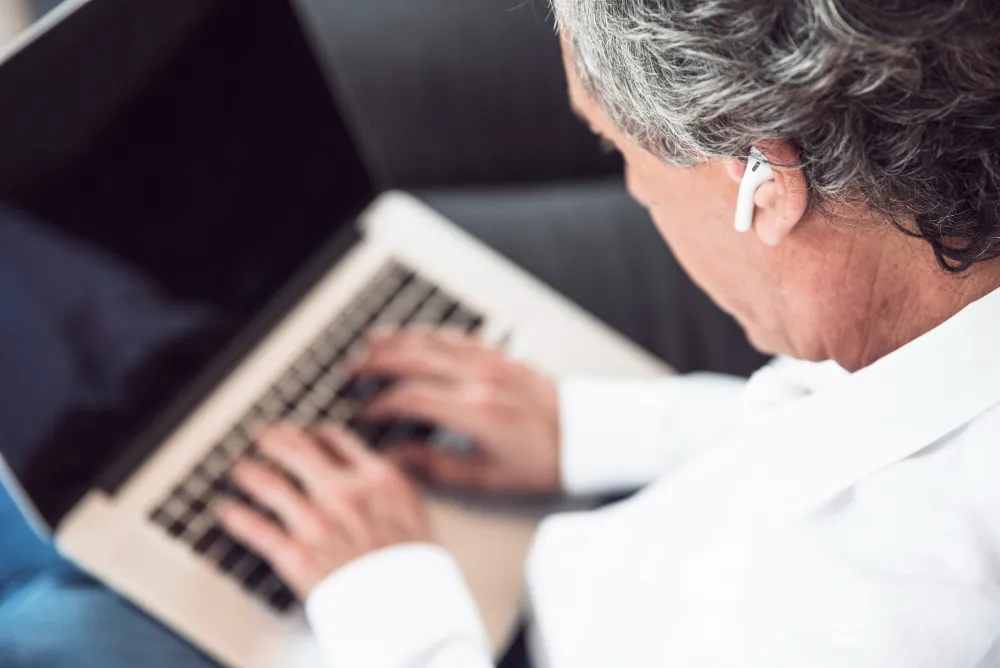 vista superior de homem de idade mexendo no notebook - dívida ativa impede aposentadoria